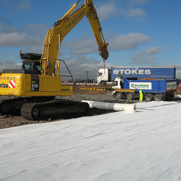 Construction vehicle installing Tensar Basetex on site 